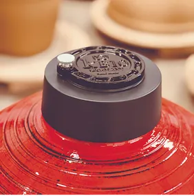 Detailaufnahme des schwarzen KB10 Aufsatzes auf einem roten Kamado