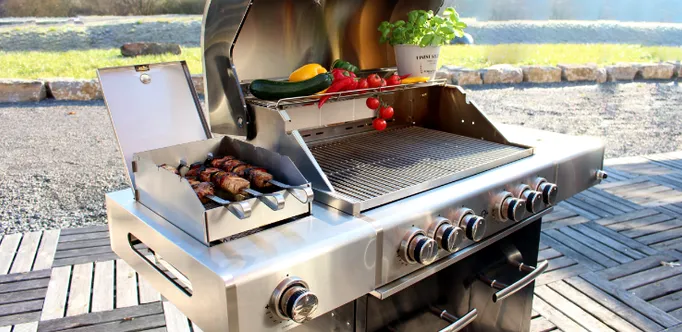 Close-up view of an ALLGRILL grill with meat skewers and vegetables on top