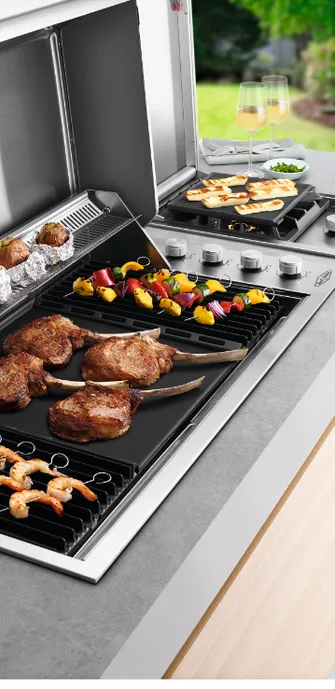 Close-up of a BeefEater outdoor kitchen grill grate loaded with meat, shrimp, and seafood