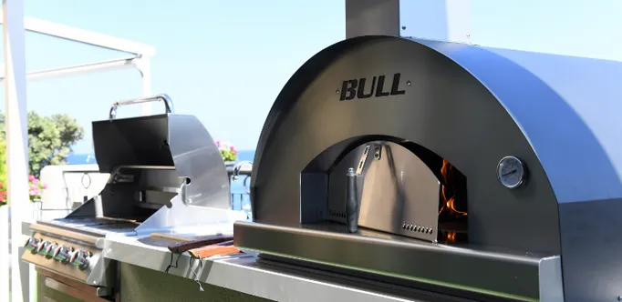Close-up of a Bull pizza oven with a Bull grill next to it