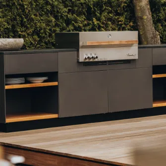 Close-up of a Flammkraft outdoor kitchen with dark gray fronts and wooden elements