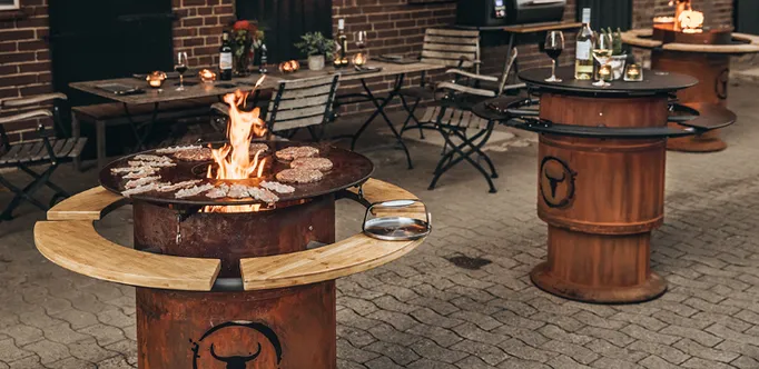 Abundantly set table on a terrace with three MOESTA Bandit fireplaces