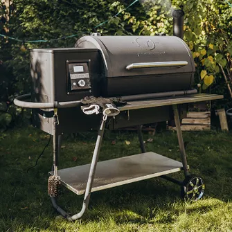 MOESTA Sheriff pellet grill on a green lawn in the garden