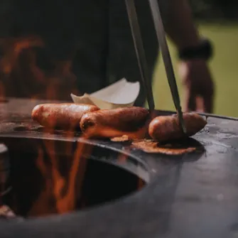 Sausages grilling on a MOESTA Bandit fireplace