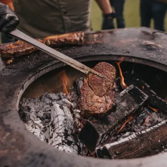 Grill steaks being grilled on a MOESTA ONE lava stone