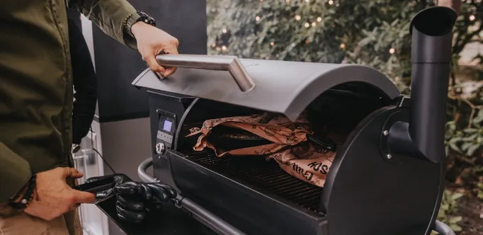 Close-up of a MOESTA Sheriff pellet grill with a grill pan on the grill grate